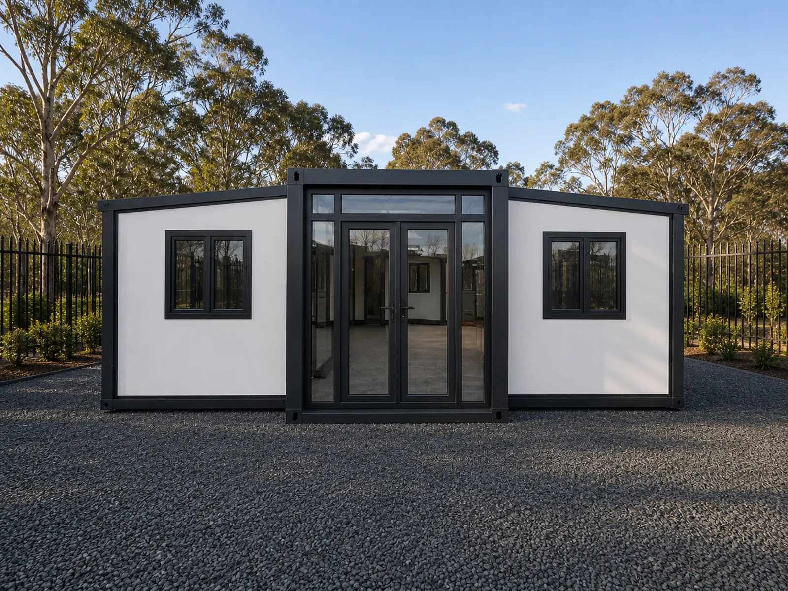 The expandable studio square on from the front, both wings folded out level with the glazed entry doors and a window in each wing
