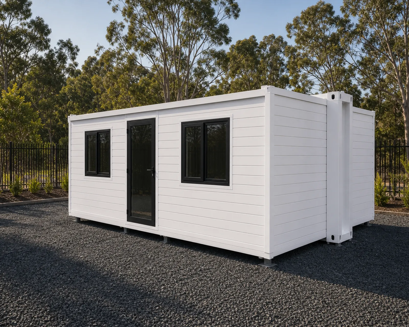 The expandable cabin from the long side, wings folded out flat with two windows and a glazed entry door along the front