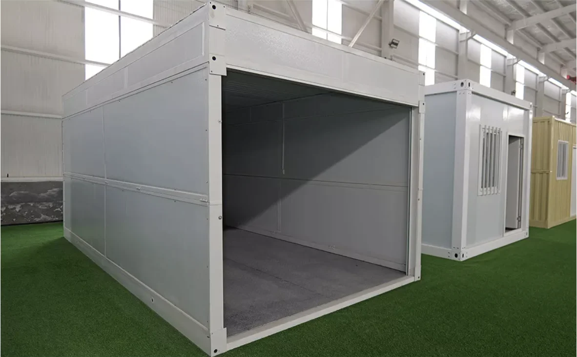 White folding garage on a factory floor with its roller door rolled up, showing the empty single bay and the concrete look floor inside