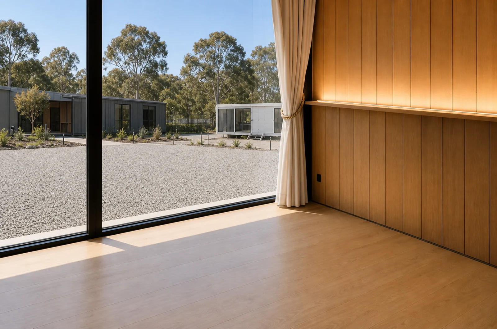 Empty interior of the 8 m mirror house, oak lined walls and floor with a curtain drawn back from the full height glazing