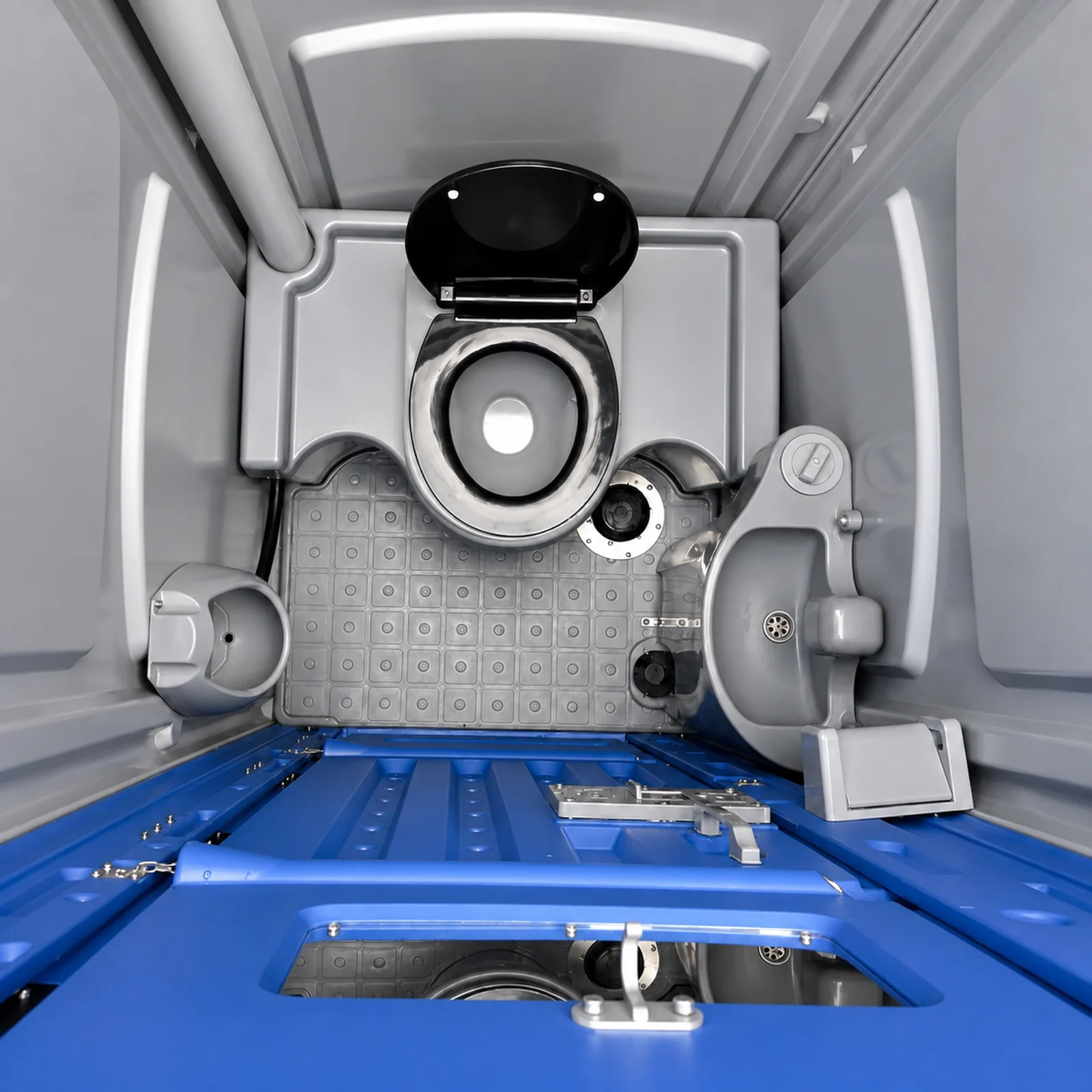 Looking down into the portaloo, the moulded seat with a closed lid, hand sanitiser dispenser and the blue floor with the waste tank access below