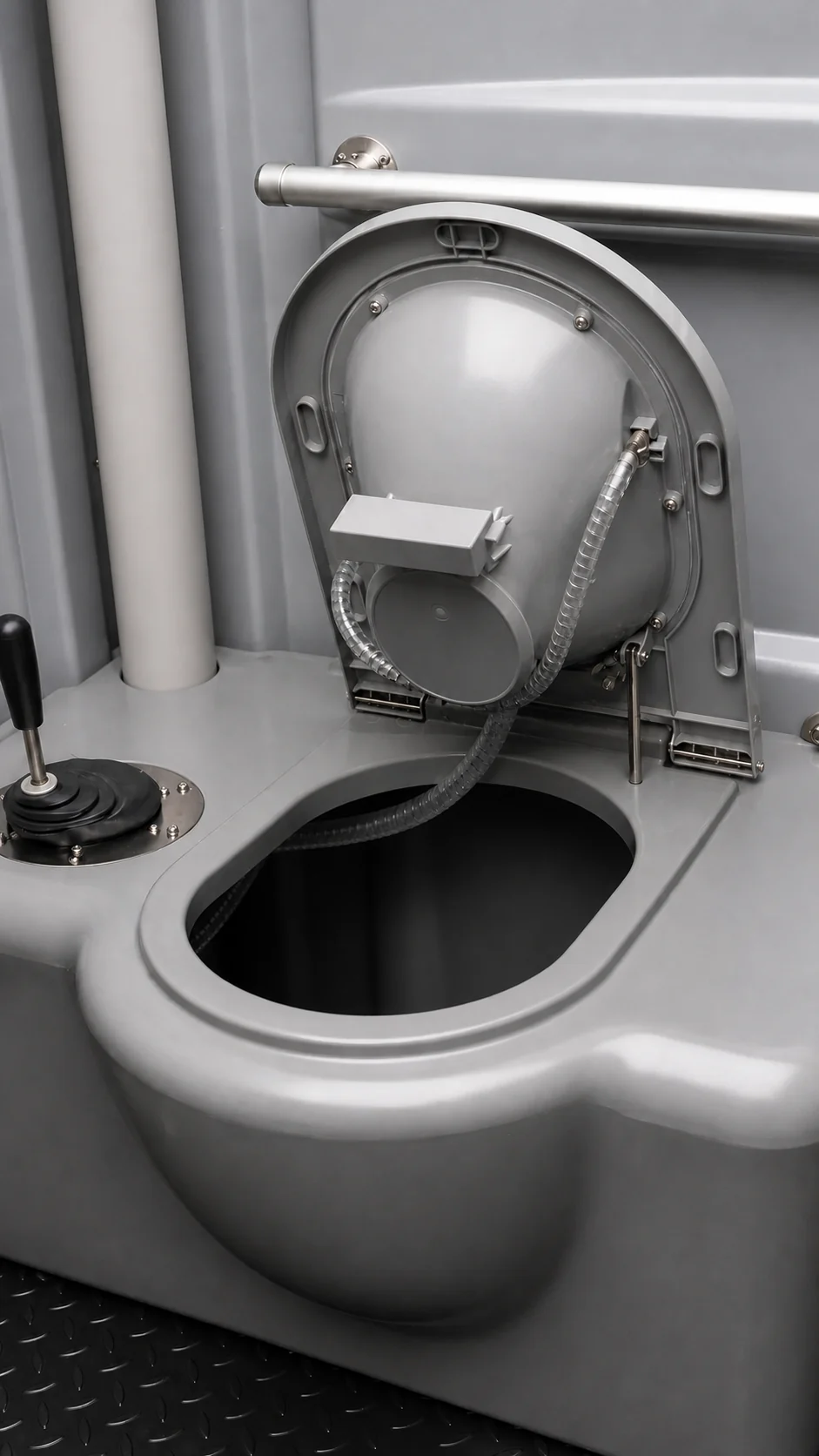 The toilet with the seat lifted, showing the flush inlet pipe and the open waste chute below