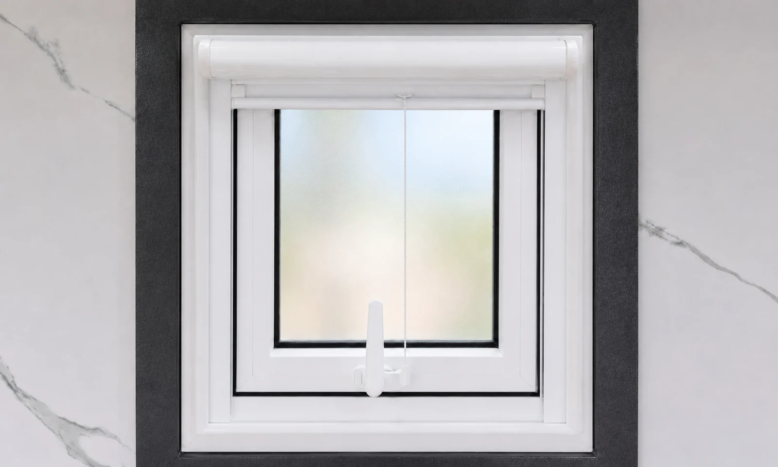 Frosted awning window in the twin toilet block with a white roller blind above and a marble look wall lining around it