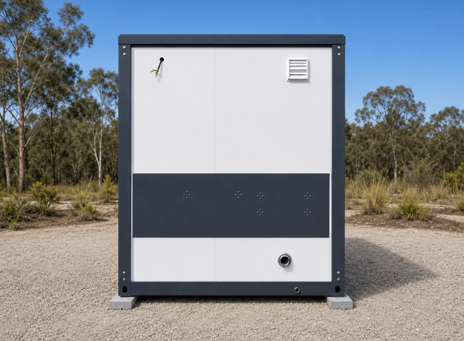 The rear of the accessible cabin, white panels with a dark band across the middle, a louvre vent and a service outlet, on a gravel pad