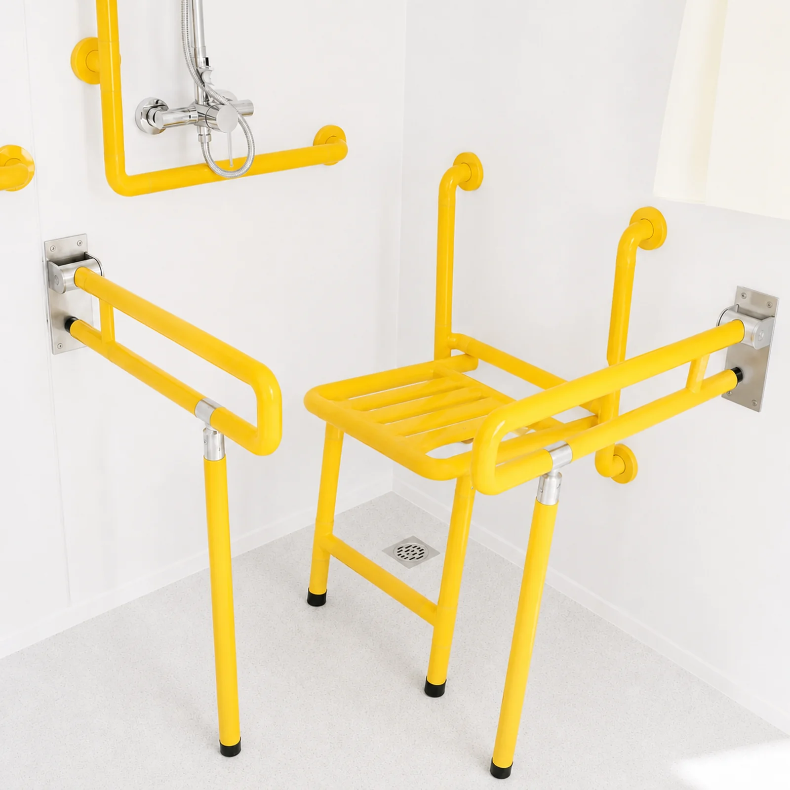 Fold down yellow shower seat with grab rails either side, a hand shower on a rail above and the floor waste below