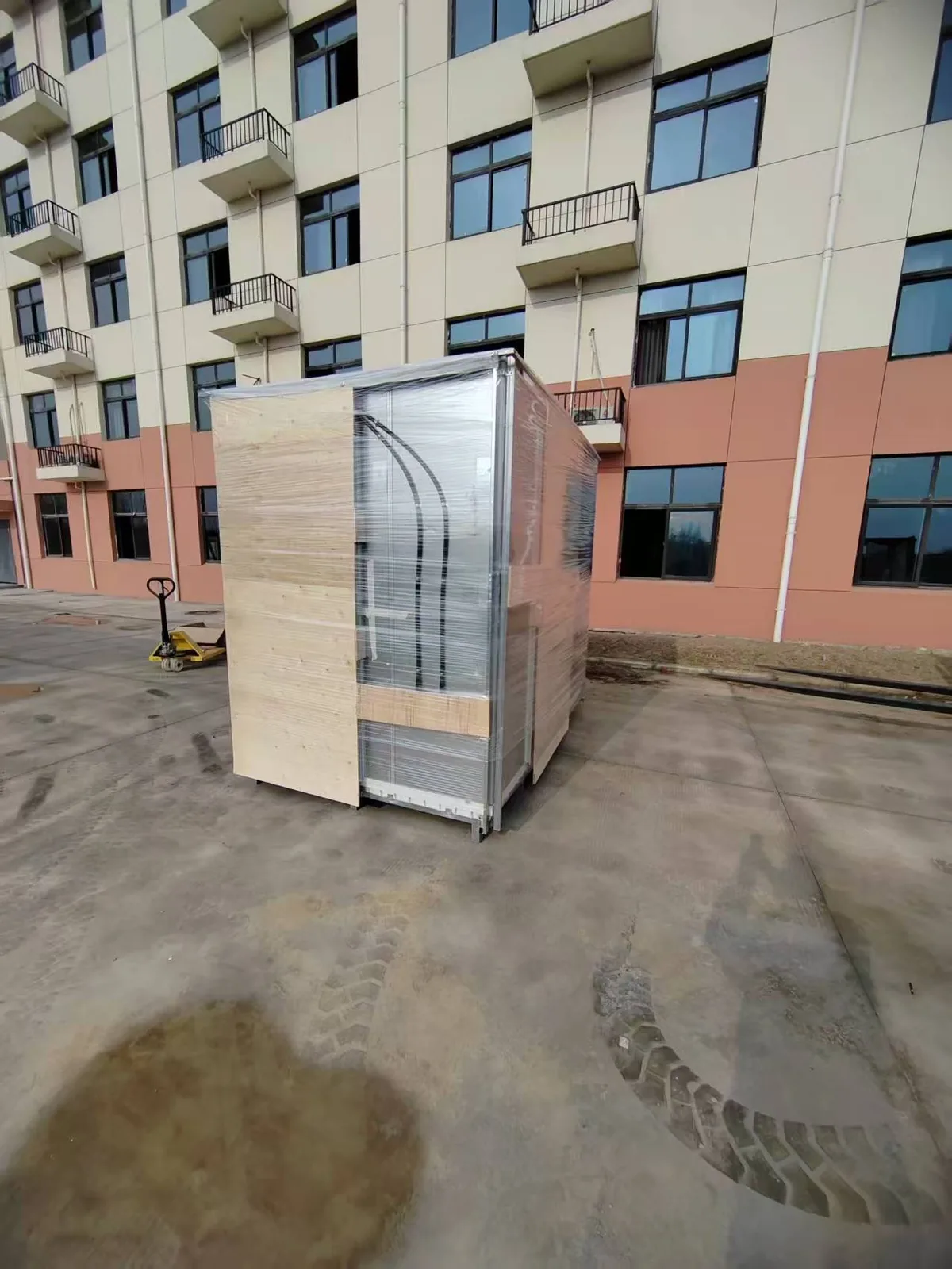 Bathroom pod crated in a timber and steel shipping frame on a hardstand, wrapped and ready for freight to Australia