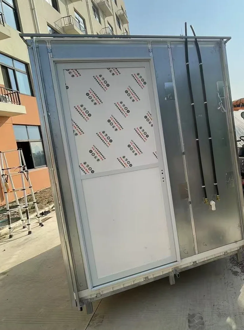 Completed bathroom pod exterior in galvanised steel with its access door and the water supply and waste connection tails brought out to one face